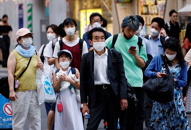 지난 7월 25일 일본 도쿄 시내에서 마스크를 쓴 행인들이 횡단 보도 앞에 모여 있다./로이터 연합뉴스