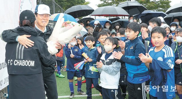 차범근 전 축구 국가대표팀 감독(왼쪽에서 두 번째)이 9일 서울 용산구 이촌 한강공원 축구장에서 열린 ‘차범근 축구교실 굿바이 페스티벌’에서 축구교실 관계자로부터 꽃다발을 받고 있다. 신원건 기자 laputa@donga.com