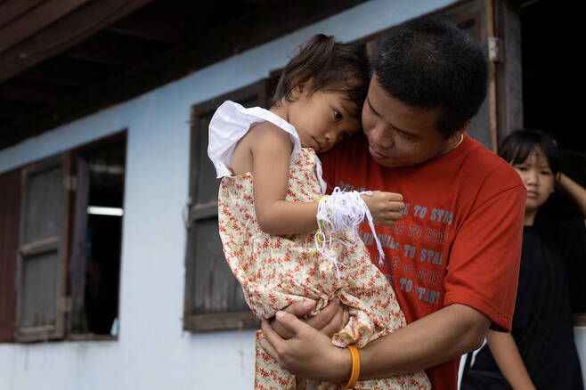 태국 농부아람푸주 우타이사완에서 9일(현지시간) 타왓차이 수폴웡이 자신의 3세 딸 파비눗 수폴웡을 안고 있다. 로이터연합뉴스