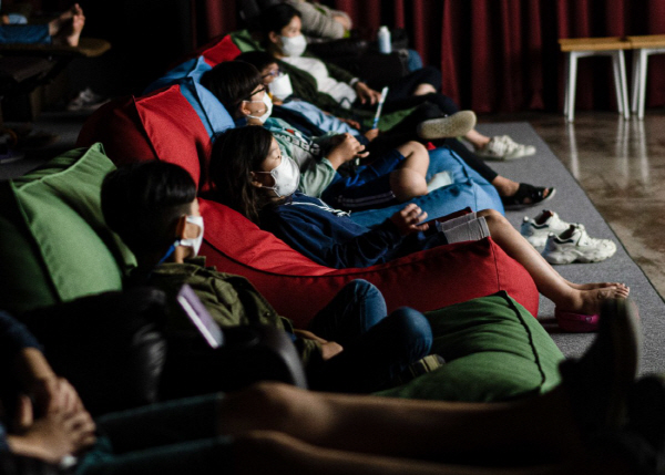 부산 북구 화명동에 위치한 독립극장 ‘무사이’에서 편안한 자세로 영화를 관람하고 있는 아이들.