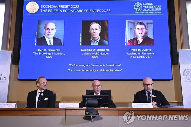 2022 노벨 경제학상 수상자 발표하는 노벨 위원회 (스톡홀름 AFP=연합뉴스) 스웨덴 왕립과학원 노벨 위원회가 10일(현지시간) 수도 스톡홀름에서 2022 경제학상 수상자를 발표하고 있다. 화면 왼쪽부터 벤 버냉키 전 미국 연방준비제도(Fed·연준) 의장, 더글러스 다이아몬드 시카고대학교 교수, 필립 딥비그 워싱턴대학교 세인트루이스 교수. 2022.10.10 alo95@yna.co.kr