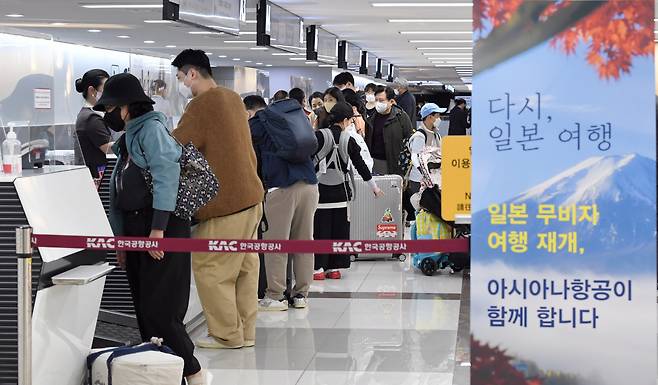 Tourist wait in line to receive tickets for Japan at Gimpo International Airport, Seoul, Tuesday. The banner on the right reads "Travel to Japan, again." (Im Se-jun/The Korea Herald)