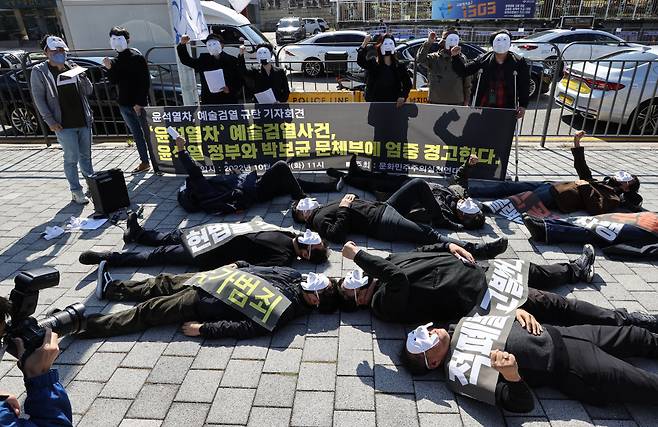 문화민주주의실천연대 등 단체 회원들이 11일 서울 용산구 대통령 집무실 인근에서 열린 '윤석열차' 예술검열 규탄 기자회견에서 가면을 쓰고 바닥에 눕는 퍼포먼스를 선보이고 있다. ⓒ연합뉴스