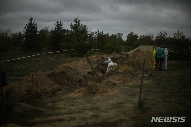 [리만=AP/뉴시스] 11일(현지시간) 우크라이나 리만의 집단 매장지에서 우크라이나 발굴단이 시신 발굴 작업을 하고 있다. 2022.10.12.