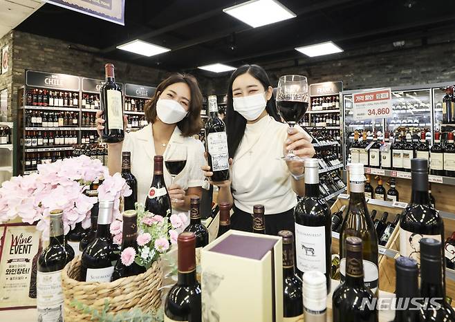 [서울=뉴시스] 김근수 기자 = 12일 서울 용산 이마트점 와인 매장에서 모델들이  1000여종의 와인을 최대 70% 할인 판매하는 '2022 하반기 와인장터' 행사를 소개하고 있다. 2022.10.12. ks@newsis.com