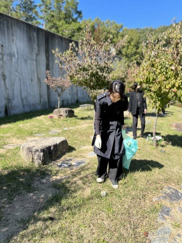 김건희 여사가 정인이 사건 2주년을 앞둔 지난 12일 경기 양평군 안데르센 메모리얼 파크를 찾아 묘역에 참배하고 주변에 쓰레기를 줍고 있다. 대통령실 제공