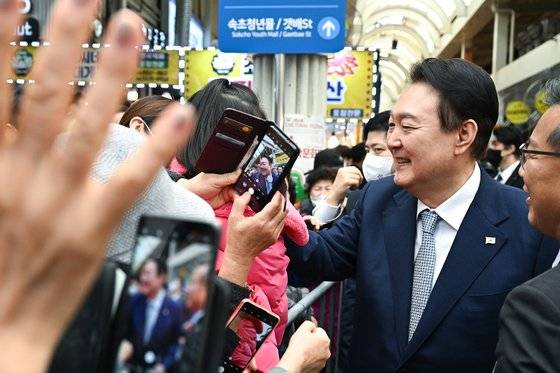 춘천~속초 동서고속화철도 착공 기념식을 위해 속초를 찾은 윤석열 대통령이 18일 강원 속초중앙시장을 찾아 시민들과 인사를 하고 있다. 사진 대통령실