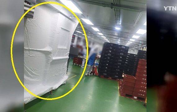 20대 여성 근로자가 숨진 배합실 사고 현장이&nbsp;흰 천으로 가려진 모습(노란 원). 그 옆에서&nbsp;다른 직원이 작업하고 있다. YTN 화면 캡처&nbsp;
