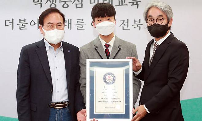 김덕은(맨 오른쪽) KRI 원장이&nbsp;19일 전북교육청에서 서거석(맨 왼쪽) 전북교육감과 함께 최연소·최다 한국 식품 국가기술자격을 취득한 한국치즈과학고 3학년 정광현 군에게 인증서를 전달한 뒤 기념 촬영하고 있다. 전북교육청 제공