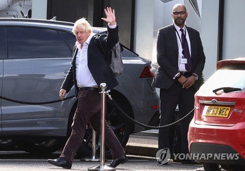 보리스 존슨 전 영국 총리가 22일(현지시간) 영국 런던 인근 개트윅 공항에 도착해 손을 흔들고 있다. [런던 로이터=연합뉴스]