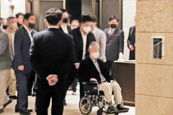 부산 최대 폭력 조직인 칠성파 전 두목 A씨의 팔순 잔치가 23일 부산시내 한 호텔에서 열렸다. A씨가 휠체어를 타고 연회장에 입장하고 있다. 송봉근 기자