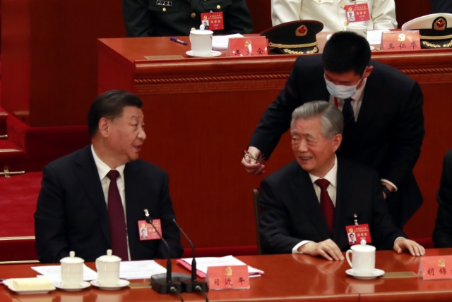후진타오(앞줄 오른쪽) 전 중국 주석이 지난 22일 수도 베이징 인민대회당에서 열린 제20차 공산당 전국대표대회 폐막식에서 퇴장을 앞두고 시진핑(왼쪽) 주석에게 웃으며 무언가를 말하고 있다. 연합뉴스