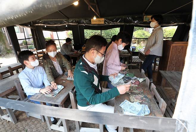 23일 오전 부산 서구 임시수도기념관에서 피란학교 천막교실 체험학습 프로그램에 참가한 학생과 학부모들이 '삐라'를 살펴보고 있다. 6·25 한국전쟁기 피란수도 부산에 대한 이해를 돕기 위해 가족 단위 관람객을 대상으로 하는 이번 프로그램은 이달부터 11월 3주까지 매주 토·일요일 하루 2회씩 진행되며, 한국전쟁 때 피란민의 생활을 체험할 수 있다./2022.10.23 김동환 기자