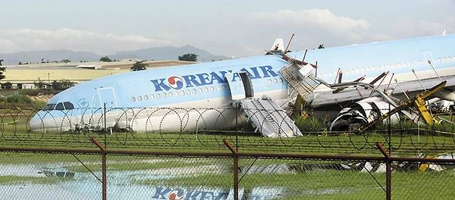 지난 23일(현지 시각) 필리핀 세부 막탄공항에 착륙하다 활주로를 이탈한 대한항공 여객기가 몸체 곳곳이 부서진 채 멈춰 있다. 당시 여객기는 날씨가 나빴던 탓에 3번의 착륙 시도 끝에 도착 예정 시각보다 1시간가량 늦게 공항 착륙에 성공했지만, 활주로를 지나 수풀에서 멈춰 섰다. 타고 있던 승객 162명과 승무원 11명 모두 인명 피해는 없는 것으로 파악됐다. /AFP 연합뉴스