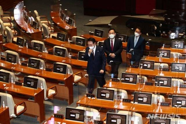 윤석열 대통령이 25일 오전 서울 여의도 국회 본회의장에서 내년도 예산안에 대한 시정연설을 마친 뒤 비어있는 더불어민주당 의원석 사이를 지나가고 있다. 사진공동취재단