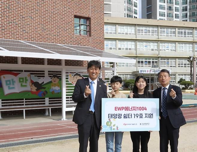 [울산=뉴시스] 구미현 기자 = 26일 울산시 남구 강남초등학교에 설치된 'EWP에너지1004' 태양광 쉼터 19호 지원식에서 김영문 동서발전 사장, 김욱년 강남초 교장과 학생들이 손가락하트 포즈를 취하며 기념사진을 촬영하는 모습. 2022.10.26. (사진=동서발전 제공) photo@newsis.com *재판매 및 DB 금지