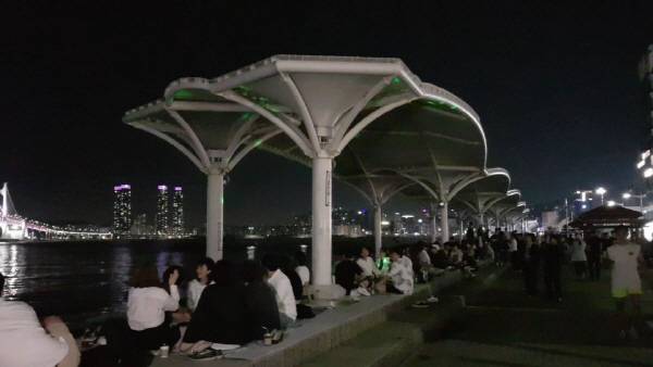 가로등이 꺼진 부산 수영구 민락수변공원에서 일부 방문객이 술을 마시고 있다. 국제신문DB