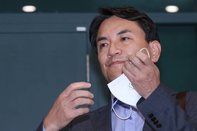 김진태 강원도지사가 27일 오후 인천국제공항 제1여객터미널을 통해 귀국한 뒤 취재진 질문을 받기 전 마스크를 벗고 있다. 인천공항=연합뉴스