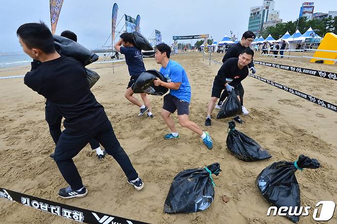 29일 경북 포항시 북구 영일대해수욕장 백사장 특설경기장에서 열린 '제2회 킹오브 더 포항'에 출전한 선수들이 장애물 구간을 통과하고 있다. .2022.10.29/뉴스1 ⓒ News1 최창호 기자