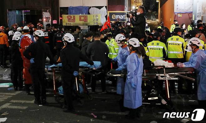 30일 새벽 서울 용산구 이태원 일대에서 의료진과 소방대원들이 압사 사고 사망자들을 이송하기 위해 대기하고 있다. 소방당국은 이번 사고로 현재까지 120명이 숨지고 100명이 부상했다고 밝혔다. 2022.10.30/뉴스1 ⓒ News1 민경석 기자