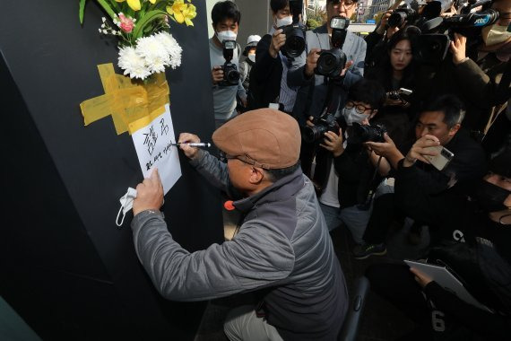 30일 오후 서울 용산구 이태원 압사 사고 현장 인근에서 한 시민이 추모를 위해 꽃을 붙이고 있다. 이번 이태원 압사 사고로 이날 현재 230명이 넘는 사상자가 발생한 것으로 집계됐다. /사진=뉴스1