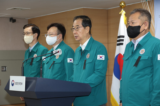 Prime Minister Han Duck-soo gives a briefing on Sunday at the government complex in central Seoul with a black ribbon on his heart. [YONHAP]