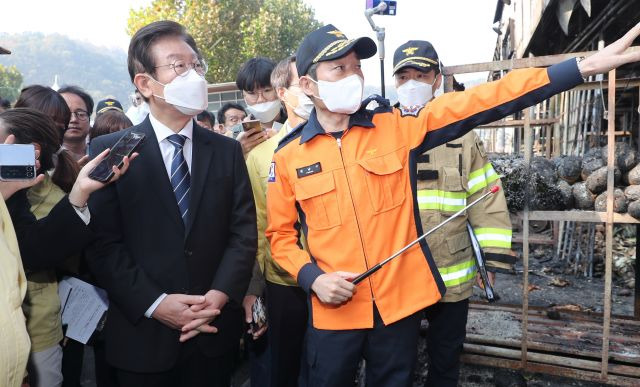 이재명 더불어민주당 대표가 28일 대구 북구 매천동 농수산물 도매시장 화재 현장을 방문해 화재 개요를 설명 듣고 있다. 연합뉴스