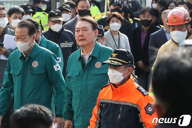 윤석열 대통령이 30일 오전 서울 용산구 이태원 핼러윈 압사사고 현장을 찾아 소방과 경찰의 설명을 들으며 살펴보고 있다.   윤 대통령은 이날 대국민 담화를 통해 "오늘부터 사고 수습이 일단락될 때까지 국가애도기간으로 정하고 국정의 최우선순위를 본 건 사고의 수습과 후속조치에 두겠다"고 말했다./사진=뉴스1