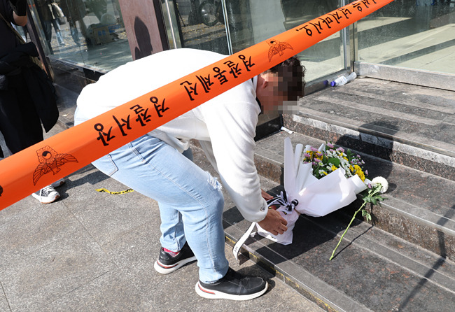 30일 한 시민이 이태원 압사 참사 현장에 추모 꽃다발을 놓고 있다. 연합뉴스