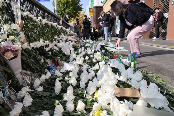 31일 오전 서울 용산구 이태원역 1번 출구 앞에 마련된 핼러윈 압사 사고 희생자 추모 공간을 찾은 시민이 헌화하고 있다. 우상조 기자