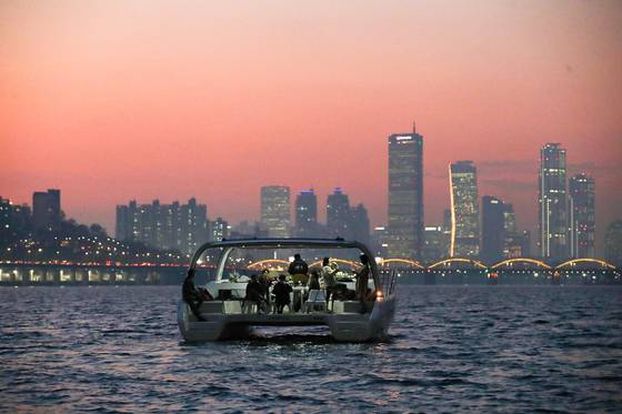 People watch the sunset from a yacht on the Han River on Nov. 12, 2020. [JOONGANG ILBO]