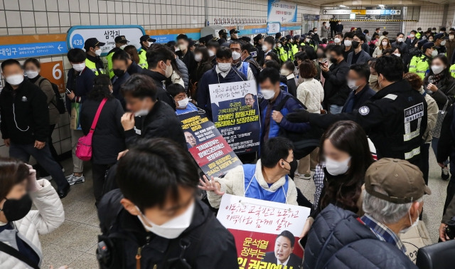 지난 25일 오전 서울 용산구 삼각지역에서 전국장애인차별철폐연대(전장연)의 장애인권리예산 등을 촉구하는 '제41차 출근길 지하철 탑니다' 시위로 시민들이 출근길에 불편을 겪고 있다. 뉴시스