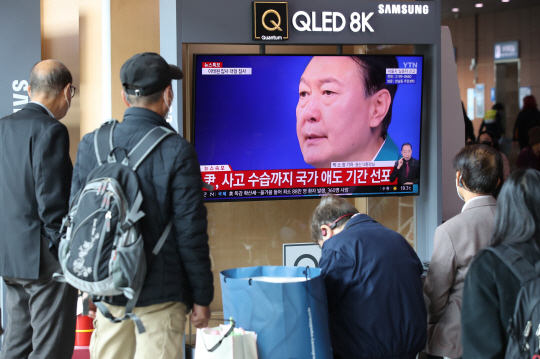 30일 서울역 대합실에서 시민들이 이태원 압사 참사 사고 관련 윤석열 대통령의 대국민 담화 발표 뉴스 특보를 시청하고 있다. 뉴시스