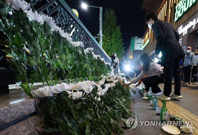 참사 하루, 계속되는 헌화와 추모 (서울=연합뉴스) 홍해인 기자 =  30일 오후 서울 용산구 지하철 6호선 이태원역 1번 출구 앞에 마련된 '핼러윈 인파' 압사 사고 희생자 추모 공간에서 시민들이 헌화하고 있다. 2022.10.30 hihong@yna.co.kr