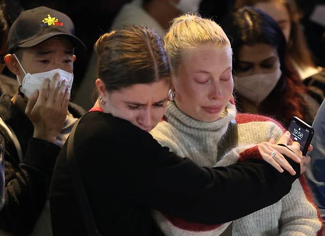 Mourners shed tears whiling paying condolences at a memorial set up near Itaewon Station in central Seoul, Monday. (Yonhap)