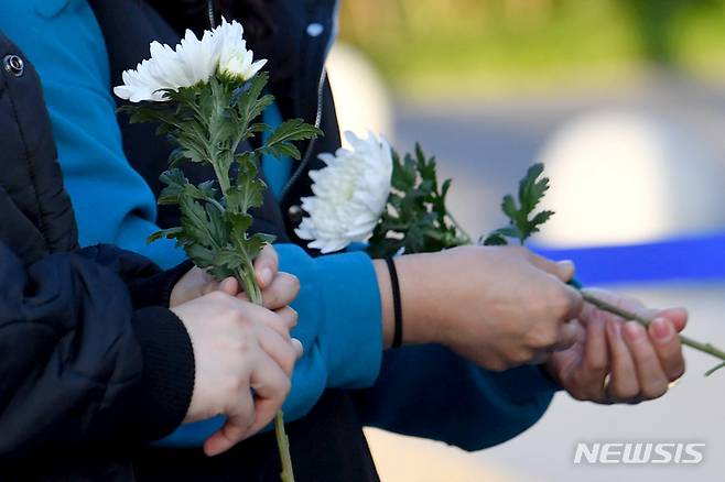 [광주=뉴시스] 이영주 기자 = 31일 오후 이태원 참사 광주시민 분향소가 차려진 광주 동구 5·18민주광장에서 시민들이 헌화하기 위해 국화를 들고 있다. 2022.10.31. leeyj2578@newsis.com