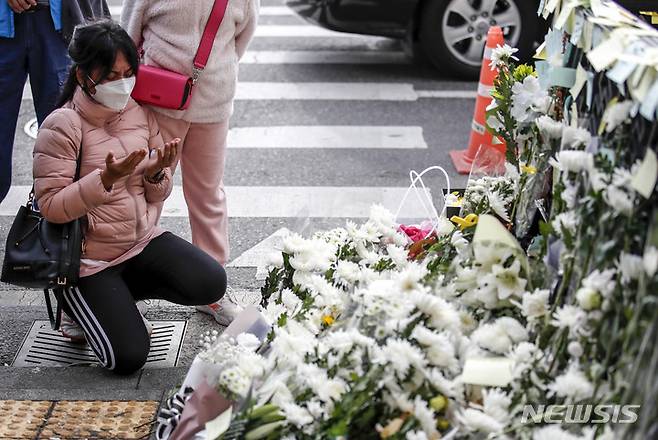 [서울=뉴시스] 정병혁 기자 = 1일 오전 서울 용산구 이태원역에 마련된 추모공간을 찾은 시민이 헌화하고 있다. 2022.11.01. jhope@newsis.com