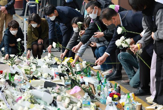 1일 서울 용산구 이태원역 1번 출구 앞 참사 추모 공간을 찾은 시민들이 단체로 헌화하고 있다.   연합뉴스