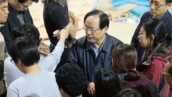 이주영 전 해양수산부 장관이 전남 진도체육관에서 세월호 피해 유가족들에게 둘러싸여 있다./조선일보 DB