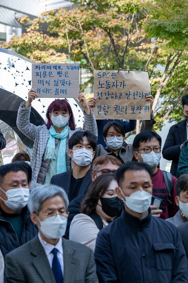 2022년 10월20일 서울 서초구 양재동 에스피씨(SPC) 본사 앞에서 열린 SPC 계열사 제빵공장의 사고로 숨진 희생자 추모 행사에서 참석자들이 ‘피 묻은 빵은 먹지 않겠다’라고 쓰인 파리바게뜨 불매 손팻말을 들고 있다. 박승화 선임기자