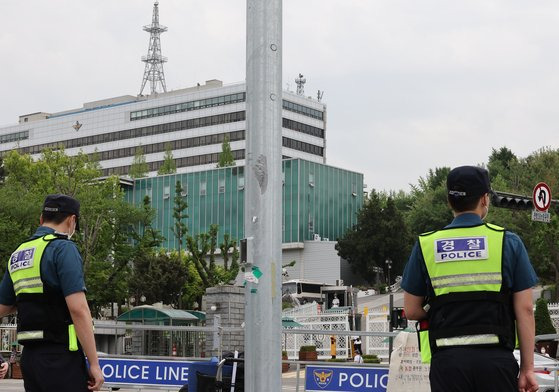 지난 5월 13일 서울 용산구 대통령실 부근 삼각지역 일대에 설치된 질서유지선 앞에서 경찰 근무자들이 1인 시위 참가자들을 살피고 있다.   연합뉴스