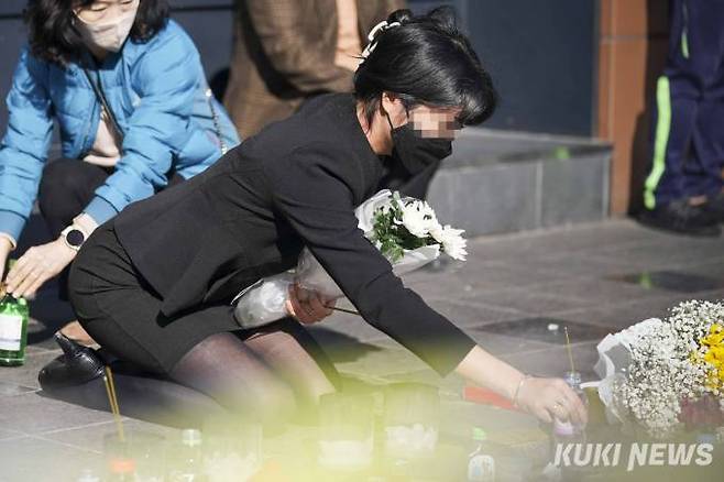 이태원 참사 발생 닷새째인 2일 오후 서울 용산구 이태원역 1번 출구 앞에 마련된 '이태원 참사' 희생자 추모공간에서 한 시민이 향을 피우고 있다.