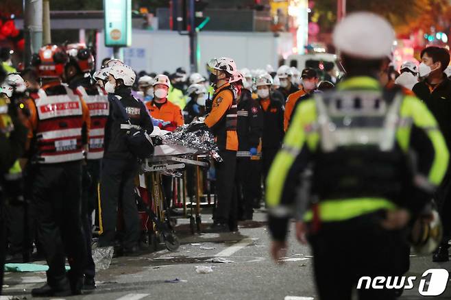 (서울=뉴스1) 민경석 기자 = 30일 새벽 서울 용산구 이태원 일대에서 의료진과 소방대원들이 압사 사고 사망자들을 이송하기 위해 대기하고 있다.  2022.10.30/뉴스1  Copyright (C) 뉴스1. All rights reserved. 무단 전재 및 재배포 금지.