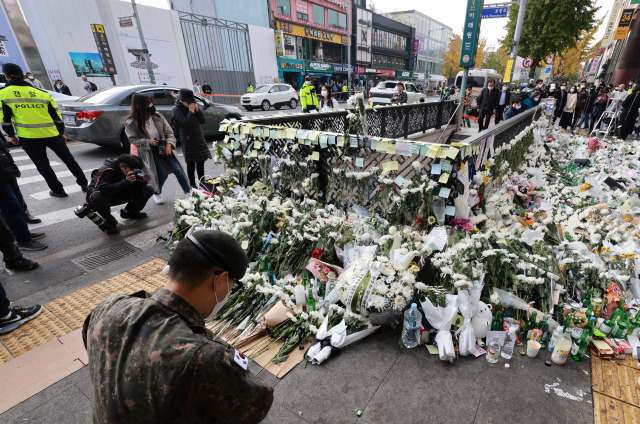 ▲1일 서울 용산구 이태원역 1번 출구 앞 참사 추모 공간에서 한 군인이 헌화한 뒤 희생자들을 추모하고 있다. ⓒ연합뉴스