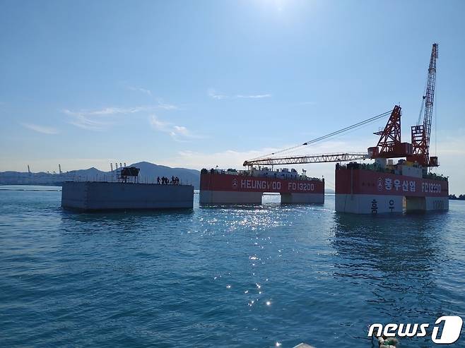 부산항 신항 서컨테이너부두 북측 해상에서 공사관게자들이 피더부두(서컨북측)건설을 위한 케이슨 설치작업을 하고 있다(부산항만공사 제공)