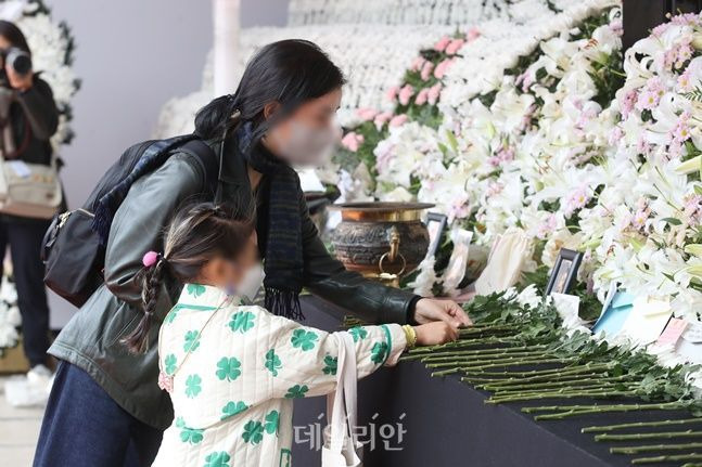 3일 서울 중구 서울광장에 마련된 이태원 사고 사망자 합동분향소에서 한 시민이 아이와 함께 헌화를 하고 있다. ⓒ데일리안 김민호 기자