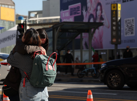 '2일 오후 서울 용산구 이태원역 1번 출구 앞 핼러윈데이 사고 희생자 추모공간을 찾은 외국인들이 눈물을 흘리고 있다. [연합뉴스]