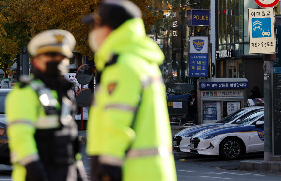 4일 오전 서울 용산구 이태원역 1번 출구 앞 참사 추모 공간에서 보이는 이태원 파출소와 근무 중인 경찰들. 2022.11.4 연합뉴스