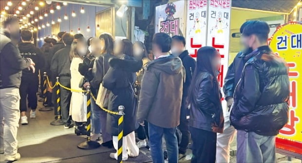 지난 5일 밤 서울 건대입구역 인근 한 식당 앞에 사람들이 줄을 서 있다.   장강호 기자