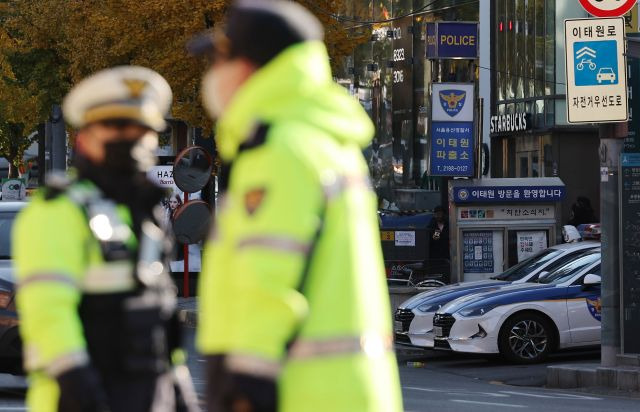 지난 4일 오전 서울 용산구 이태원역 1번 출구 앞 참사 추모 공간에서 보이는 이태원 파출소와 근무 중인 경찰들. 연합뉴스